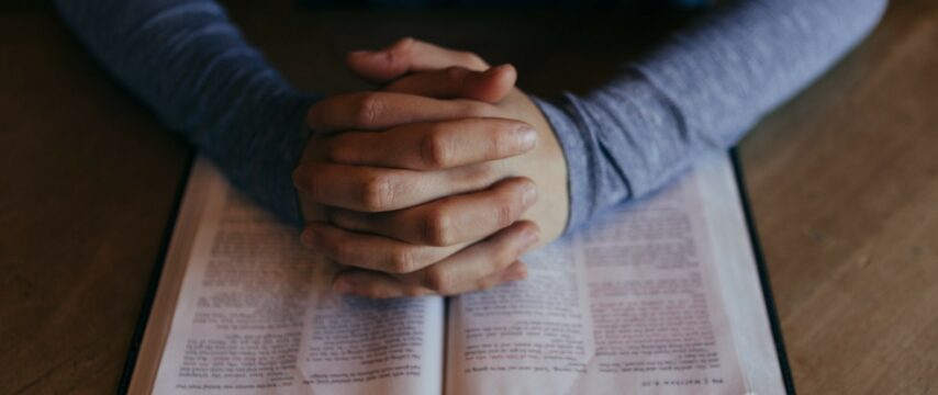 biddende man met bijbel